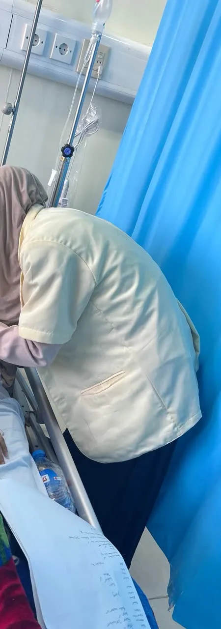 Henni in a nutrition jacket at a hospital bedside during the dietetic internship